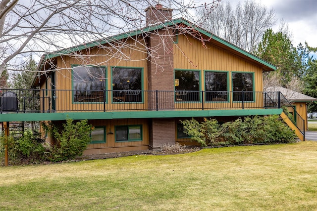 back of house featuring a yard, stairway, and a chimney
