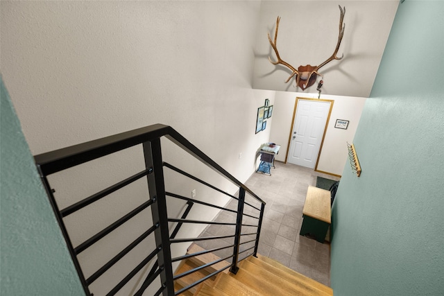 staircase with baseboards and a textured wall