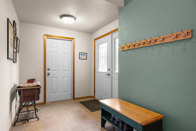 entryway with light tile patterned floors and baseboards