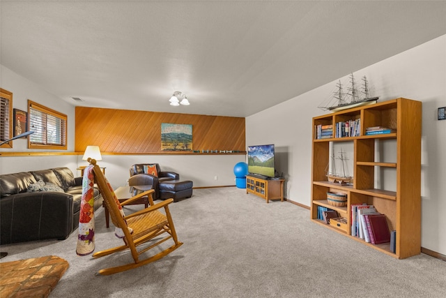 living area featuring visible vents, baseboards, and carpet