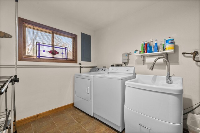 washroom with laundry area, electric panel, a sink, baseboards, and washer and clothes dryer
