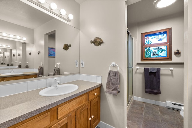 full bath featuring a shower stall, vanity, a baseboard heating unit, and baseboards