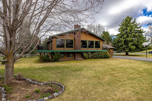 back of house featuring a yard, stairs, a deck, and a chimney