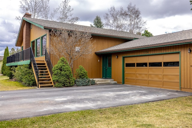 view of front facade with a chimney, a garage, and driveway