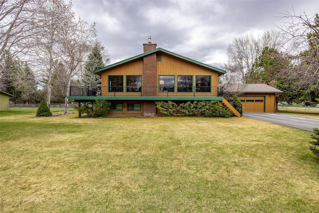 exterior space featuring a yard, aphalt driveway, a chimney, fence, and stairway
