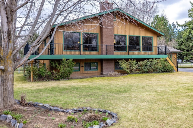 rear view of house featuring a wooden deck, a lawn, and a chimney
