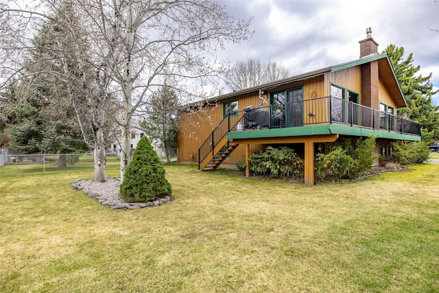 view of yard featuring fence, a wooden deck, and stairway