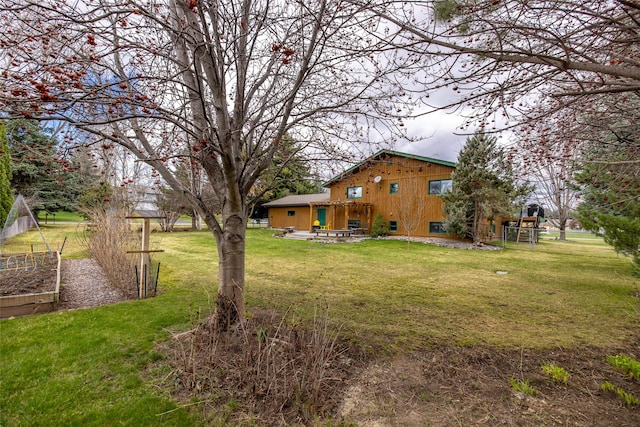 view of yard featuring fence and a vegetable garden