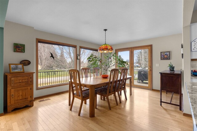 dining space featuring visible vents, baseboards, and light wood-type flooring