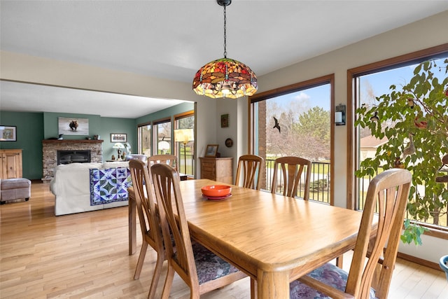 dining area with light wood-style flooring and a fireplace