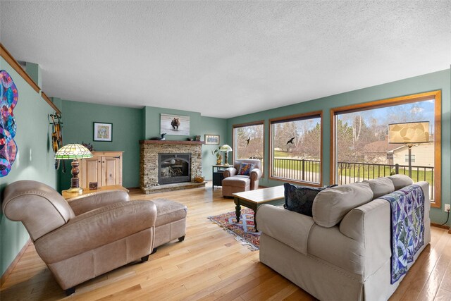 living area with hardwood / wood-style floors, a fireplace, and a textured ceiling