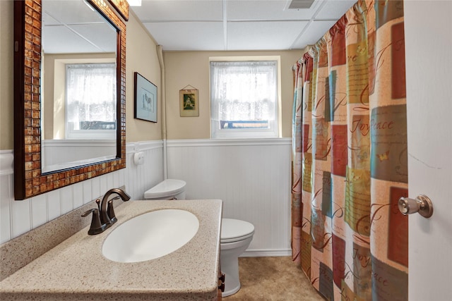 bathroom with vanity, visible vents, a wainscoted wall, toilet, and curtained shower