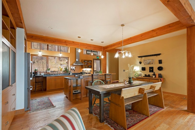 dining space featuring light wood-style floors and a notable chandelier