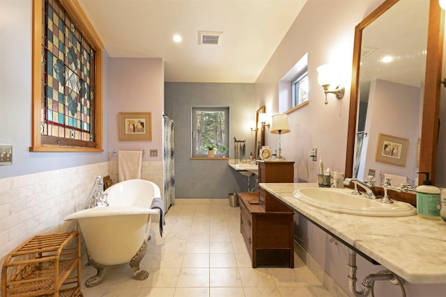 bathroom featuring curtained shower, visible vents, wainscoting, a freestanding bath, and tile walls