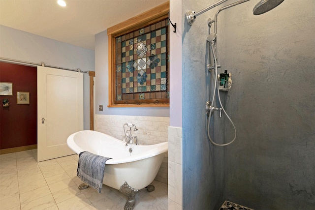 bathroom featuring a freestanding tub, tile patterned flooring, a shower stall, wainscoting, and tile walls