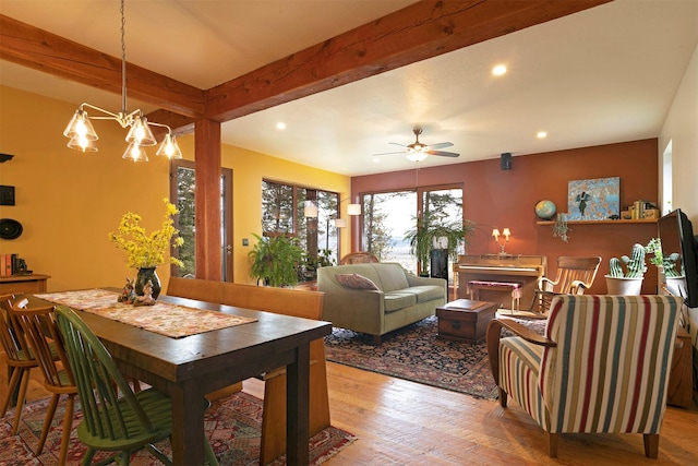 dining room with recessed lighting, wood-type flooring, ceiling fan with notable chandelier, and beamed ceiling