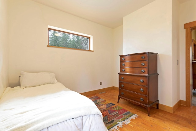 bedroom with light wood-style flooring and baseboards