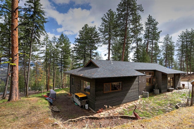 view of home's exterior with roof with shingles and central air condition unit