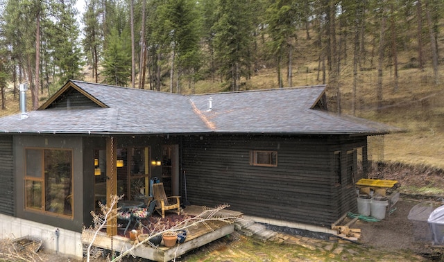 rear view of house with a shingled roof