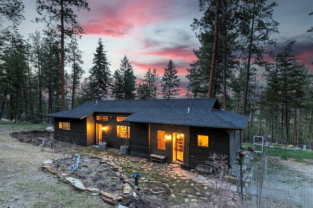 rear view of house with roof with shingles