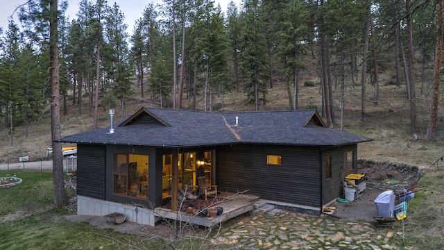 rear view of property with a shingled roof
