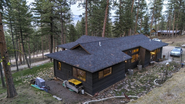 view of side of property featuring roof with shingles