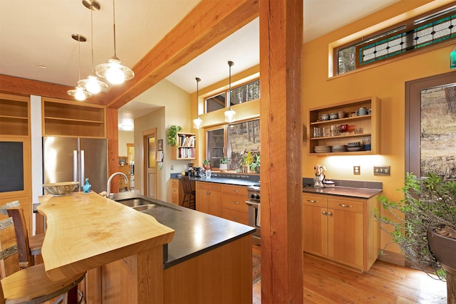 kitchen featuring freestanding refrigerator, open shelves, beam ceiling, light wood finished floors, and a sink