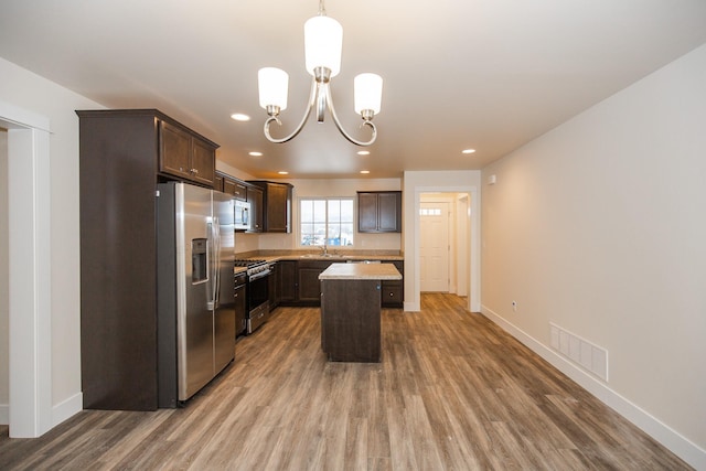 327 Meadow View Loop, East Helena, MT 59635 - kitchen with visible vents, a notable chandelier, appliances with stainless steel finishes, dark brown cabinets, and light wood finished floors