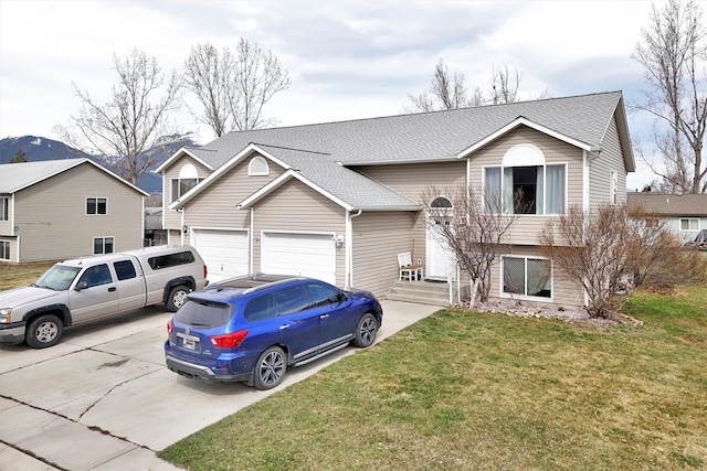 split foyer home with an attached garage, roof with shingles, concrete driveway, and a front yard