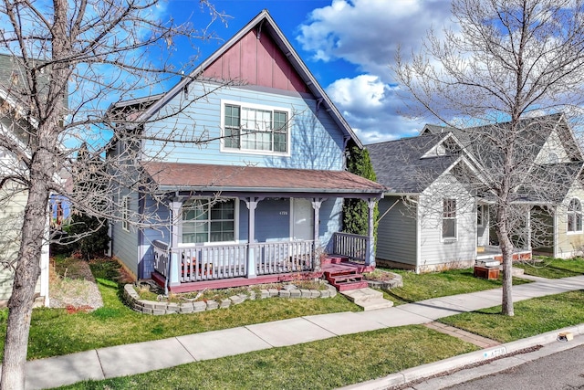 view of front of property featuring a porch, roof with shingles, and a front lawn