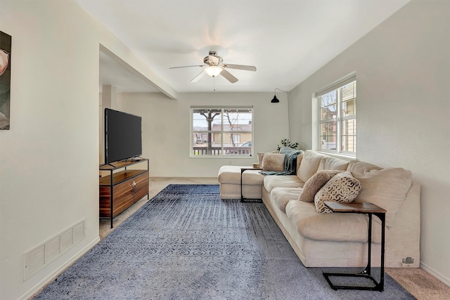 living room featuring a wealth of natural light, visible vents, and a ceiling fan