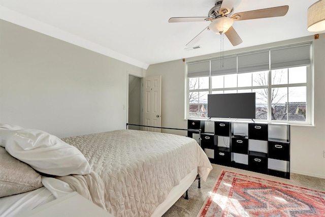 carpeted bedroom with visible vents, multiple windows, and ceiling fan