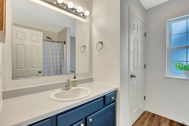 full bathroom with baseboards, curtained shower, vanity, and wood finished floors