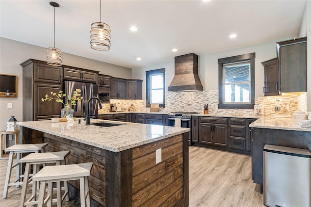 124 Hidden Waters Ln, Kalispell, MT 59901 - kitchen featuring wall chimney range hood, a sink, stainless steel appliances, dark brown cabinets, and recessed lighting