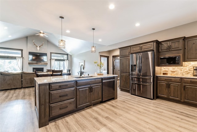 124 Hidden Waters Ln, Kalispell, MT 59901 - kitchen featuring stainless steel appliances, a sink, healthy amount of natural light, dark brown cabinetry, and vaulted ceiling