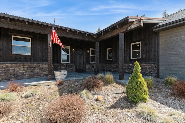 124 Hidden Waters Ln, Kalispell, MT 59901 - entrance to property with covered porch, stone siding, and board and batten siding
