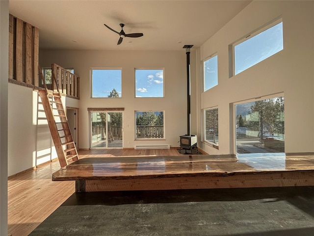519 Grizzly Dr, Thompson Falls, MT 59873 - unfurnished sunroom featuring a wood stove, baseboard heating, and a healthy amount of sunlight