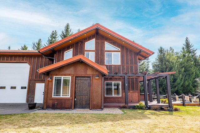 chalet / cabin with board and batten siding, a garage, and a front yard