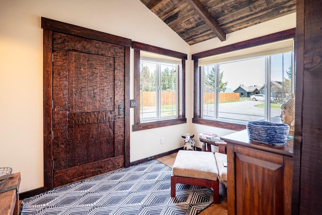 sitting room with wooden ceiling, lofted ceiling with beams, and baseboards
