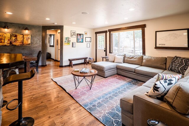 living area with wood finished floors, baseboards, and recessed lighting