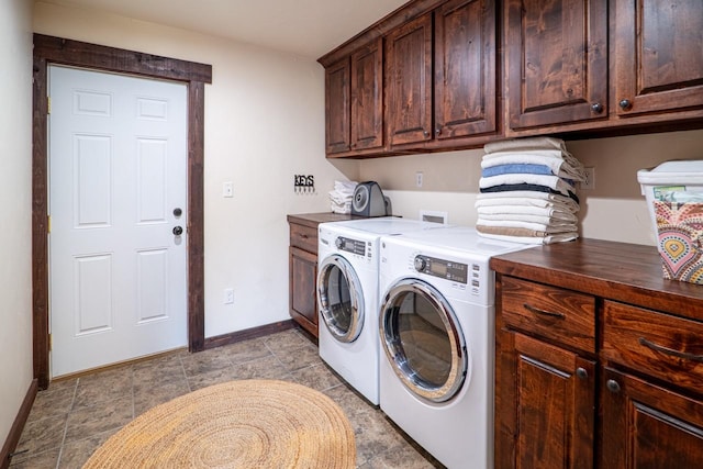 washroom with cabinet space, washer and clothes dryer, and baseboards