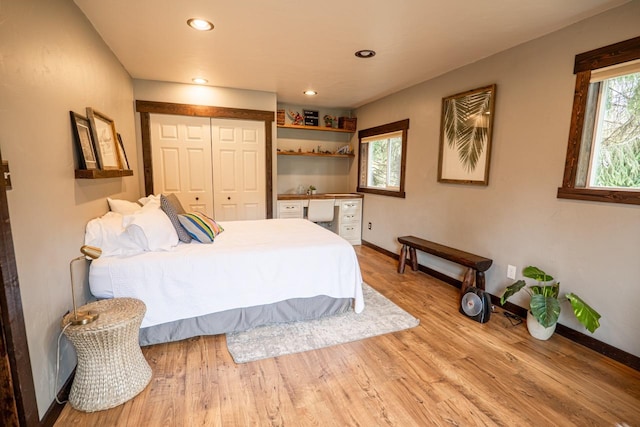bedroom with wood finished floors, baseboards, a closet, and recessed lighting