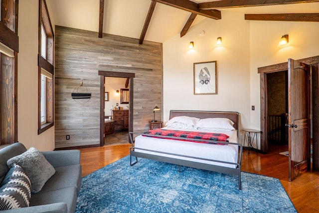 bedroom with beam ceiling, high vaulted ceiling, and wood finished floors