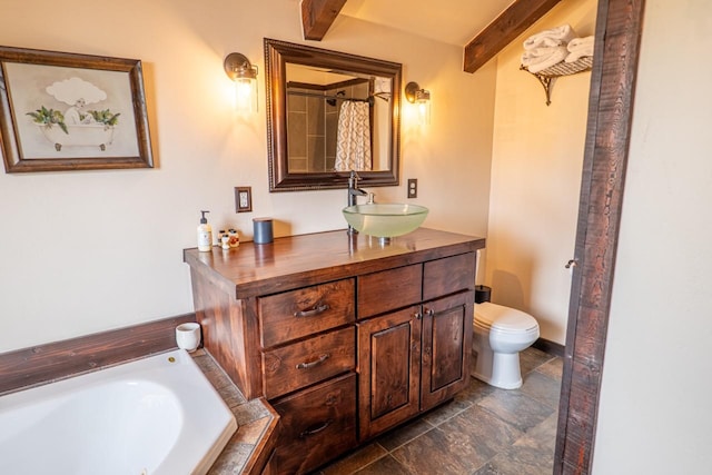 full bath featuring vanity, toilet, a bath, beamed ceiling, and stone finish flooring