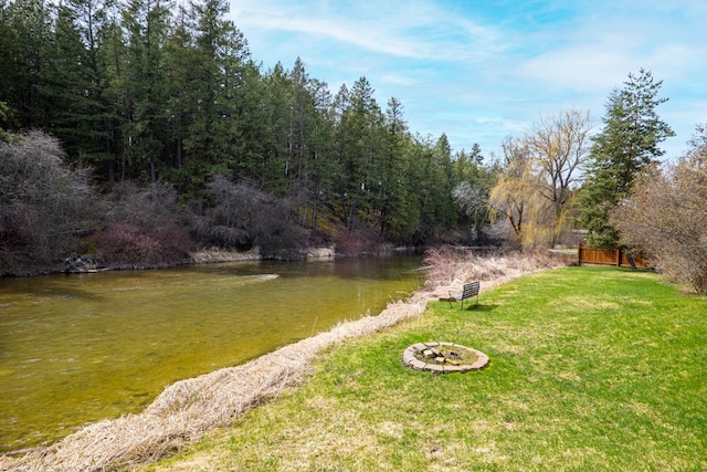 view of yard featuring a water view and a fire pit