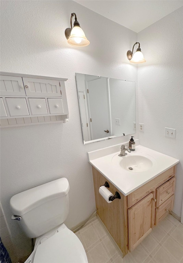 bathroom featuring tile patterned floors, vanity, and toilet