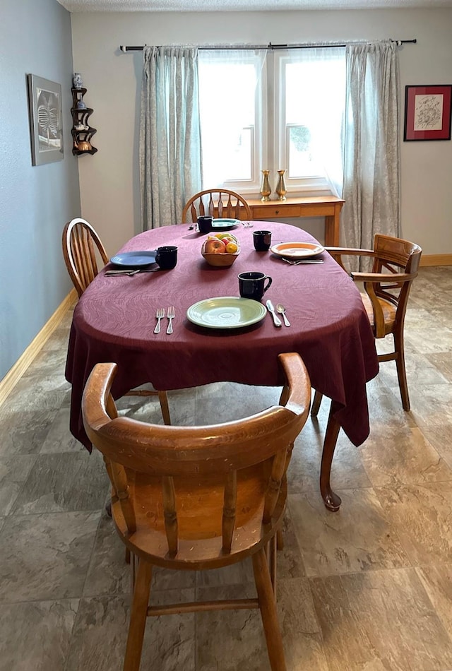 dining area with baseboards and stone finish flooring