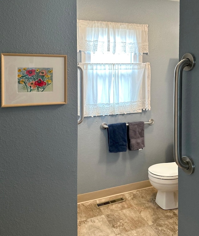 bathroom with toilet, baseboards, and visible vents