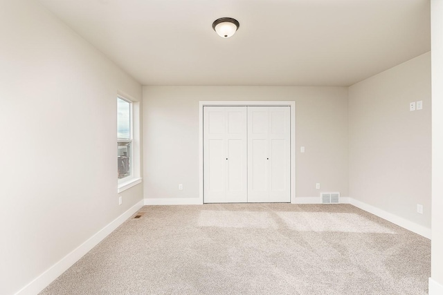 unfurnished bedroom featuring visible vents, baseboards, a closet, and carpet