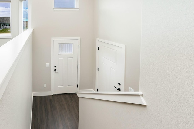foyer entrance featuring baseboards and dark wood finished floors